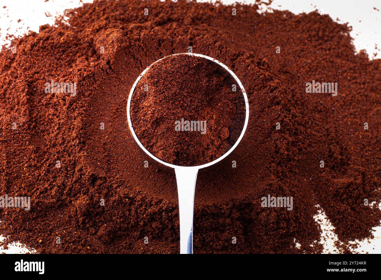 Cuillère dans la poudre de café brun. Isolé sur blanc. Parfait comme image de fond. Espace vide pour le texte. Banque D'Images