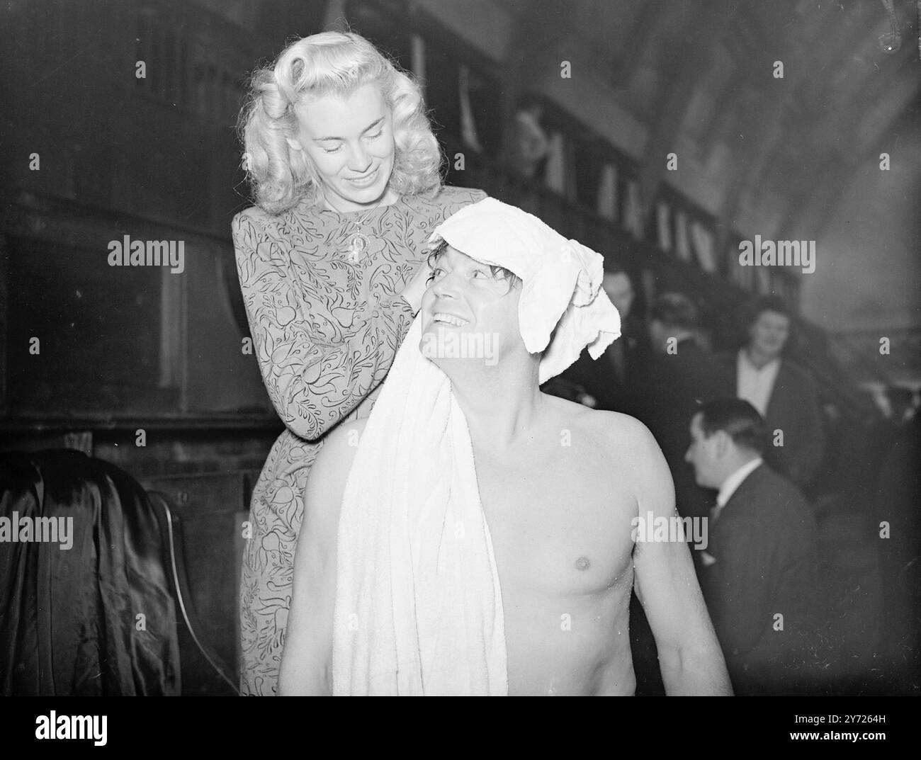 Dans le temps avec 'Tarzan'. Malgré le fait que 'Tarzan' des singes (Johnny Weismuller) est l'homme puissant dans sa jungle natale, il doit encore se faire sécher les cheveux par Mme Weismuller après une répétition de natation pour son prochain spectacle aquatique à Earls court. 16 février 1948. Banque D'Images