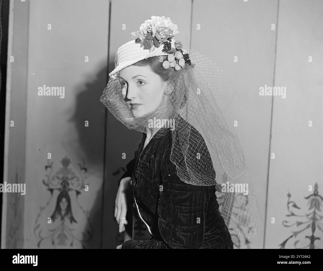 Mode Decrees un retour à porter des fruits sur la tête avec ce petit chapeau de marin édouardien gay en paille blanche fantaisie décoré avec des contributions du jardin de fleurs hoth et du verger. Veilling Framing the face ajoute une touche sophistiquée à cette nouvelle création printanière. 3 avril 1948. Banque D'Images