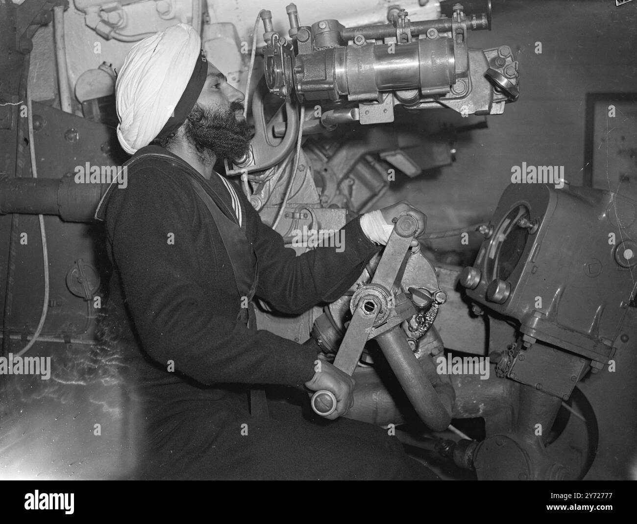 Les hommes de la marine indienne s'entraînent pour reprendre les officiers de la marine indienne qui sont en Angleterre pour finalement reprendre le croiseur HMS Achilles suivent des cours dans un certain nombre d'établissements de la Royal Naval au Royaume-Uni avant la mise en service du navire. À l'heure actuelle, certains d'entre eux sont à Portsmouth où ils apprennent l'artillerie et le combat armé à bord du «navire à terre sèche», le HMS excellent. L'image montre : un sikh en formation au HMS excellent, apprend à poser un canon de 4,7 Mark XII, similaire à ceux qui arment les Achille. 23 février 1948 Banque D'Images