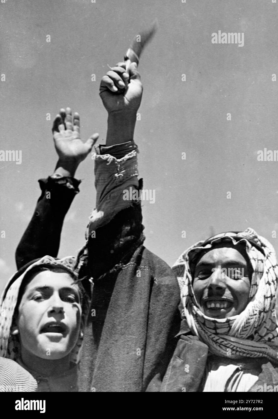 Les troupes de la Légion arabe ont acclamé sur leur chemin vers le champ de bataille. Des photos montrent ; agitant un couteau, un homme de Transjordanie donne une acclamation aux troupes de la Légion arabe sur leur chemin vers le front de bataille. 23 mai 1948 Banque D'Images