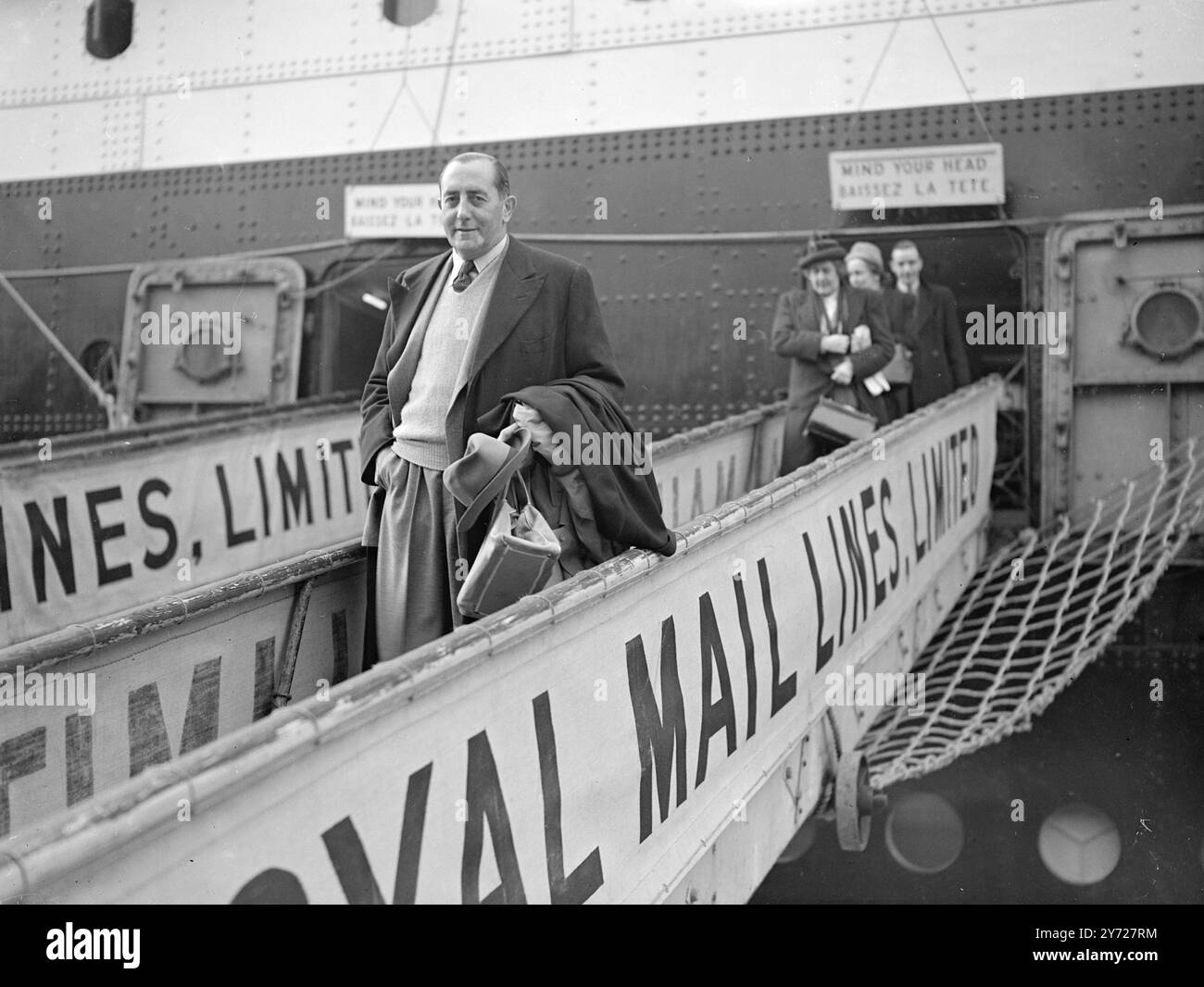 Maison avec la viande. La première cargaison de viande en vertu du nouvel accord commercial est arrivée à Southampton aujourd'hui (samedi) à bord du paquebot de luxe Royal mail de 26 000 tonnes Andes en provenance de l'Agentine. La photo montre : «Bringing Home the Bacon» Sir Clive Baillieu, chef de la mission commerciale britannique, s'éloigne des Andes à Southampton, ce matin. 28 février 1948 Banque D'Images
