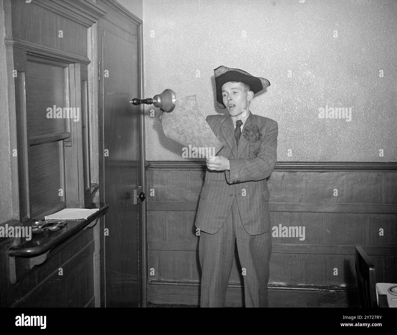 'No Sinatra' avec une affiche proclamant 'je ne suis pas Sinatra, mais je suis le choix inrationné des ménagères', Owen.L.Roberts, 30 ans, ex-pilote de pathfinder, fait une candidature pour le vote féminin dans les prochaines élections partielles de Wigan, (sondage du 4 mars). En tant que « Kings Cavalier », M. Roberts parcourt la ville habillé comme le crier de la ville. Il porte une grande cloche, et lit sur un parchemin. Photos : 'Housewives Choice'-Mr Owen.L.Roberts faisant campagne à Wigan. 2 mars 1948 Banque D'Images