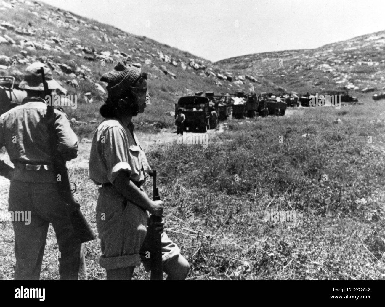 Les approvisionnements arrivent à Jérusalem par la route secrète de la brousse. Pendant la bataille de Latroun, peu avant la paix en Palestine, la Légion arabe a réussi à couper la ligne de vie de Jérusalem - l'autoroute de tel Aviv. Pour ne pas être battus, les Juifs ont été gardés top secret jusqu'à ce qu'il soit révélé après le cessez-le-feu. Comme la route est toujours utilisée constamment pour approvisionner Jérusalem, elle est naturellement contestée. Les photos montrent ; alors que les approvisionnements circulent le long de la route secrète de la brousse vers Jérusalem, deux personnes montent la garde - juste au cas où. 28 juin 1948 Banque D'Images