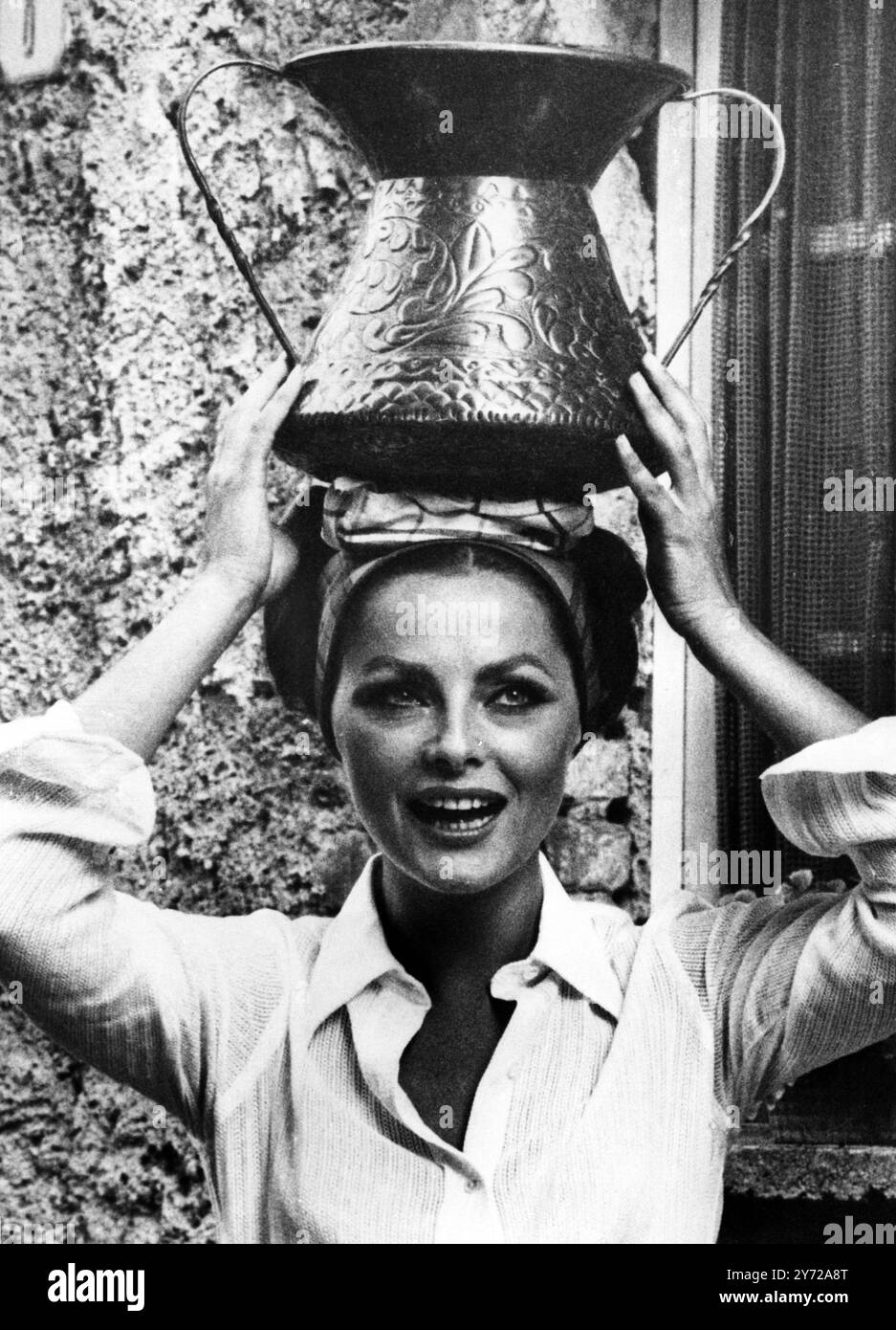 L'actrice italienne Virna Lisi porte un pot d'eau en cuivre orné dans une scène de son dernier film ' le secret de Santa Vittoria ' dans le village d'Anticoli Corrado . 15 août 1968 Banque D'Images