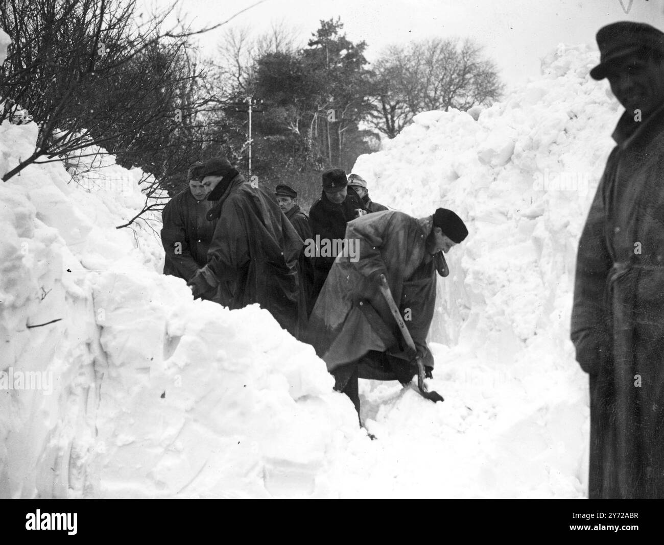 Les prisonniers allemands se frayaient un chemin à travers les dérives de neige de 8 et 10 pieds de profondeur aujourd'hui. Sur la route de Folkestone à Paddlesworth (kent), où les villageois sont isolés depuis vendredi. Un nouveau blizzard menace maintenant de défaire tout le travail qui a déjà été fait. 6 mars 1946 Banque D'Images