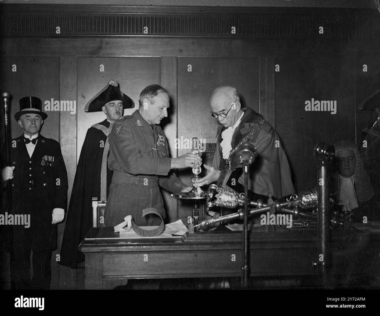 Liberté de Hastings conférée au maréchal. Vicomte Montgomery d'Alamein aujourd'hui. Lorsque le conseiller municipal F. W Chambers lui présenta un morceau de plaque gravé avec les noms de ses victoires ornées de tableaux en émail de navires de combat des Cinque ports, surmontés d'une figure dorée de Saint Michel (saint patron de Hastings) ; le vicomte Montgomery recevant la liberté de l'arrondissement du Maher, Cllr Chambers lors d'une réunion spéciale du conseil municipal au pavillon de roche blanche. 8 mars 1946 Banque D'Images