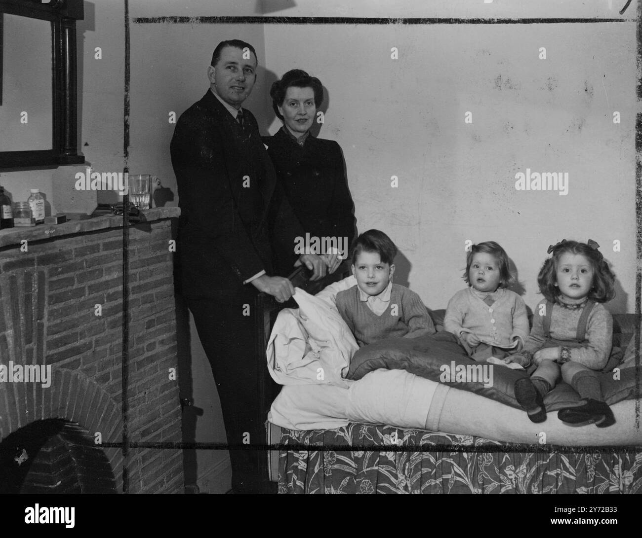 Une nouvelle série de photos du neveu de Sir Charles Vyner Brooke, Rajah de Sarawak avec sa femme et ses enfants prises à leur domicile londonien, 31 Prince Albert Road, NW8. Images : Lionel 5 1/2 ans fils de M. et Mme Brooke, est visité dans sa chambre par la famille pendant la convalescence d'une attaque de grippe. De gauche à droite :- M. et Mme Brooke, Lionel, Celia et Angela. 21 février 1946 Banque D'Images