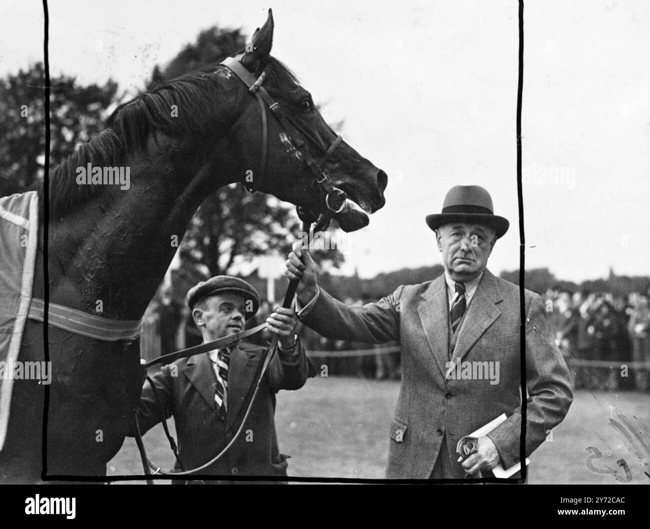 L'Arbar de M Marcel Boussac, favori de départ pour les 2 miles King George VI Stakes à Ascot cet après-midi, a justifié la confiance de ses bailleurs de fonds en remportant dans un style fringant le Mombasa de M. David Miln, monté par K Gethin. M Boussacs a également fourni le troisième cheval dans cette importante course de Cadir, monté par R Poincelet. Le jockey d'Arbar était C Elliot. Images : Arbar a l'air un vainqueur plein d'esprit car il reçoit les félicitations de son propriétaire, Mons Marcel Boussac après sa grande course à Ascot aujourd'hui. 11 octobre 1947 Banque D'Images