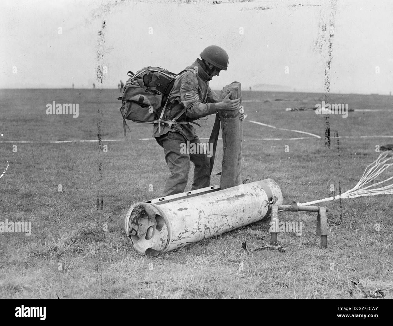 Les premières manœuvres aéroportées à avoir lieu en Grande-Bretagne depuis le début de la guerre à Netheravon, Wilts, aujourd'hui (lundi). Connue sous le nom d'exercice 'Longstop', l'opération comprend le largage d'environ 700 parachutistes lors d'un assaut initial. Des planeurs, plus de troupes de parachute et des jeeps parachutées et six fondateurs seront largués pour les soutenir. Trois bataillons participent, deux, et la première phase de parachute et de planeur, la troisième, avec des bras de soutien, arrive par avion lorsque l'aérodrome est solidement tenu. La photo montre, un parachutiste enlève des fournitures vitales d'une caisse de fournitures parachutée. 23 Septembe Banque D'Images