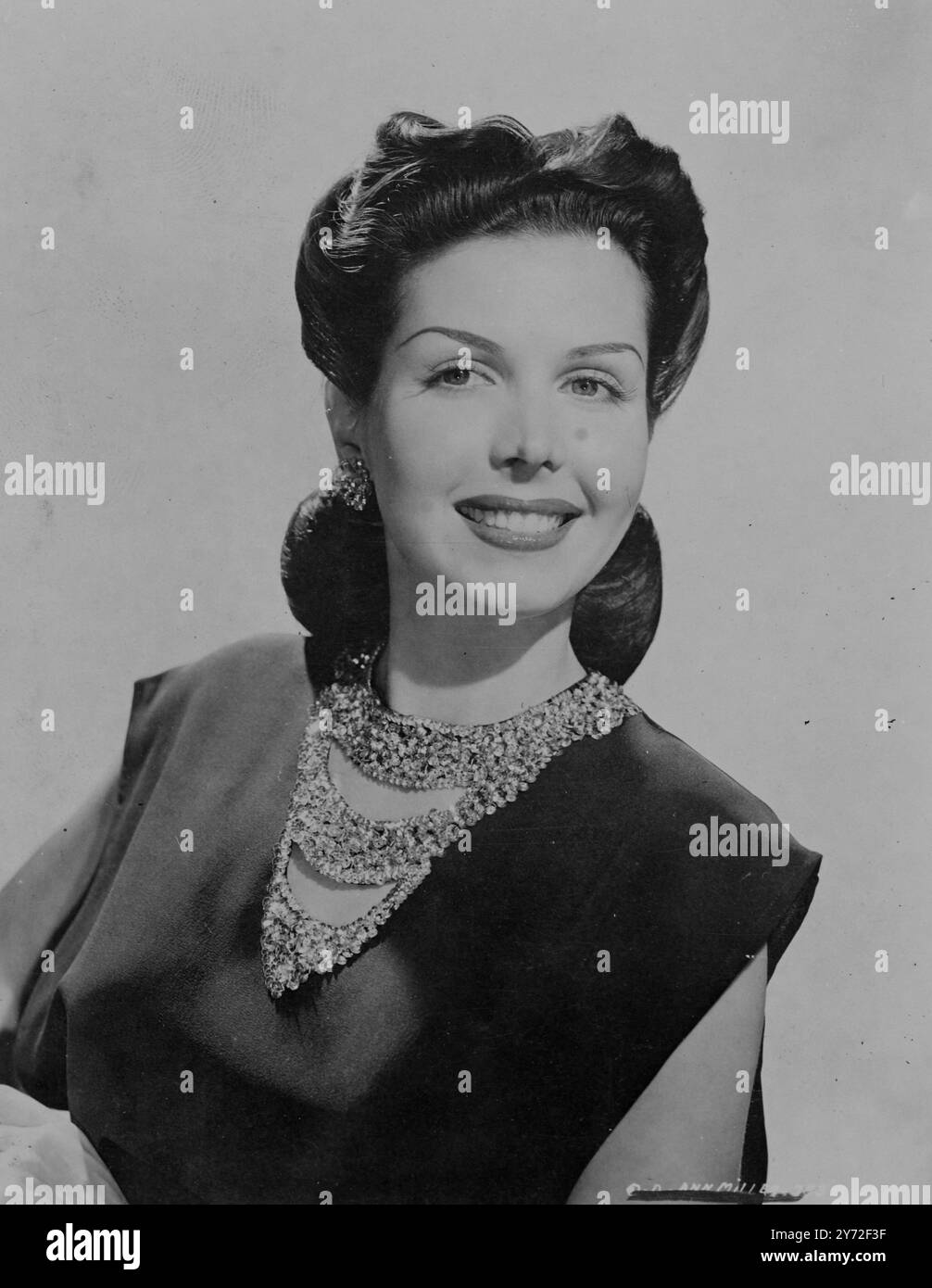 La jolie fille. La beauté de Brunette Ann Miller est de retour aux Columbia Studios et filme dans une nouvelle comédie musicale 'The Petty Girl'. Cette étoile dansante brillante a une nouvelle coiffure élégante pour l'occasion, avec des vagues lâches balayées en arrière et enroulées derrière les oreilles. Son chemisier est un style inhabituel, connu sous le nom de blousette, il est similaire à la populaire «Dickey» bien qu'il puisse être porté avec ou sans veste, car il se noue sur les côtés de sorte qu'il n'y a pas de lacunes. façonné en crêpe marron. La blousette est brodée autour de l'encolure avec des sequins chartreuse étincelants. 4 août 1947 Banque D'Images