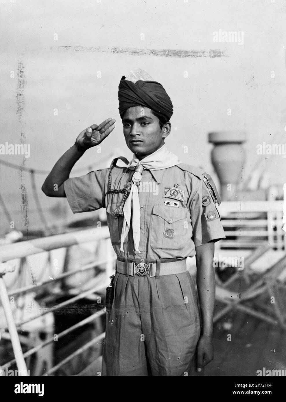 150 Boy Scouts indiens participeront au jamboree mondial à Moisson, près de Paris, est arrivé à Southampton. Avant d'aller en France, ils passeront une quinzaine de jours à visiter en Angleterre. Sa Majesté le Roi rencontrera les 500 Scouts au Palais de Buckingham. Les images montrent : un bon type de Scout indien fait des images impressionnantes qu'il fait le salut Scout à bord du SS Alcantara à Southampton. 24 juillet 1947 Banque D'Images