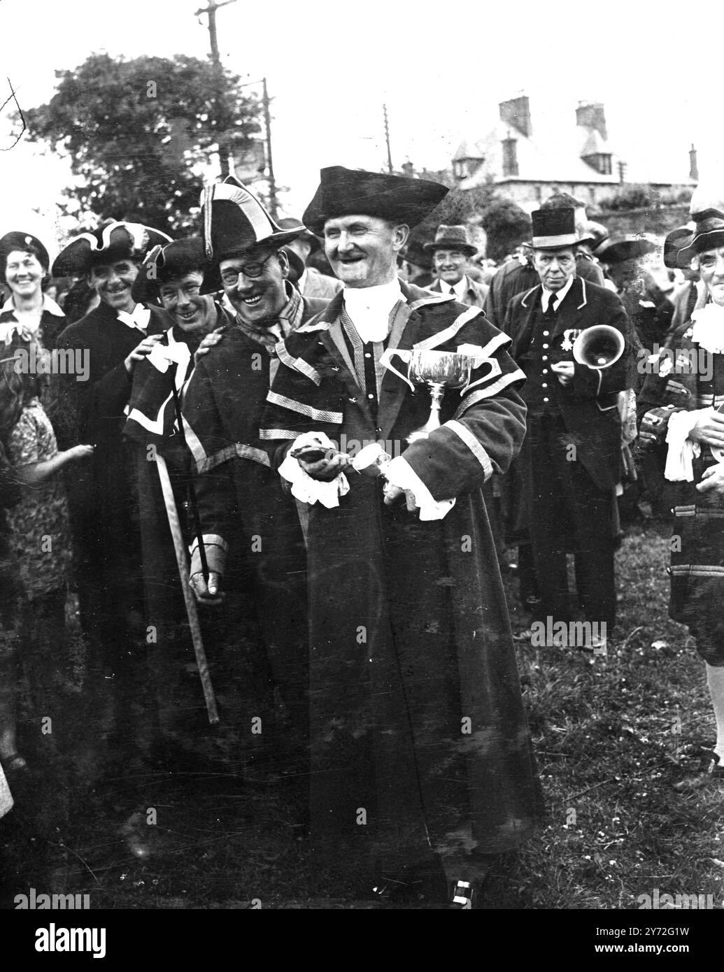 Le National Town crier's Championship Contest a eu lieu à Nicholas Meadow, Bodmin, Cornwall pour la « News of the World » Challenge Cup. Photos : les quatre premiers lauréats vus à Bodmin. En face de la coupe est F. Welch - gagnant du premier prix pour la deuxième fois. Ensuite, J.S.L. Morris qui était champion précédent. Dans une émission récente en Amérique, il a déclaré qu'il n'avait pas de bas blancs à porter et a été inondé d'offres. Derrière lui, le champion B.T.Hohnson -1939 a pris la troisième place. H. Thistleton, de Warwick, qui a remporté le quatrième prix est vu à l'arrière. 17 juillet 1947 Banque D'Images