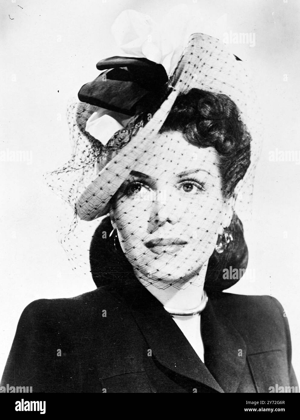 Belle Colombie style Ann Miller semble son devenir le plus mignon dans ce chapeau de haut en bas en feutre rose. Doubles baies de ruban noir et rose et un air jaunâtre, et le voile qui peut être porté sur le visage de replié sur la couronne du chapeau comme la touche finale de l'intelligence. 9 juillet 1947 Banque D'Images