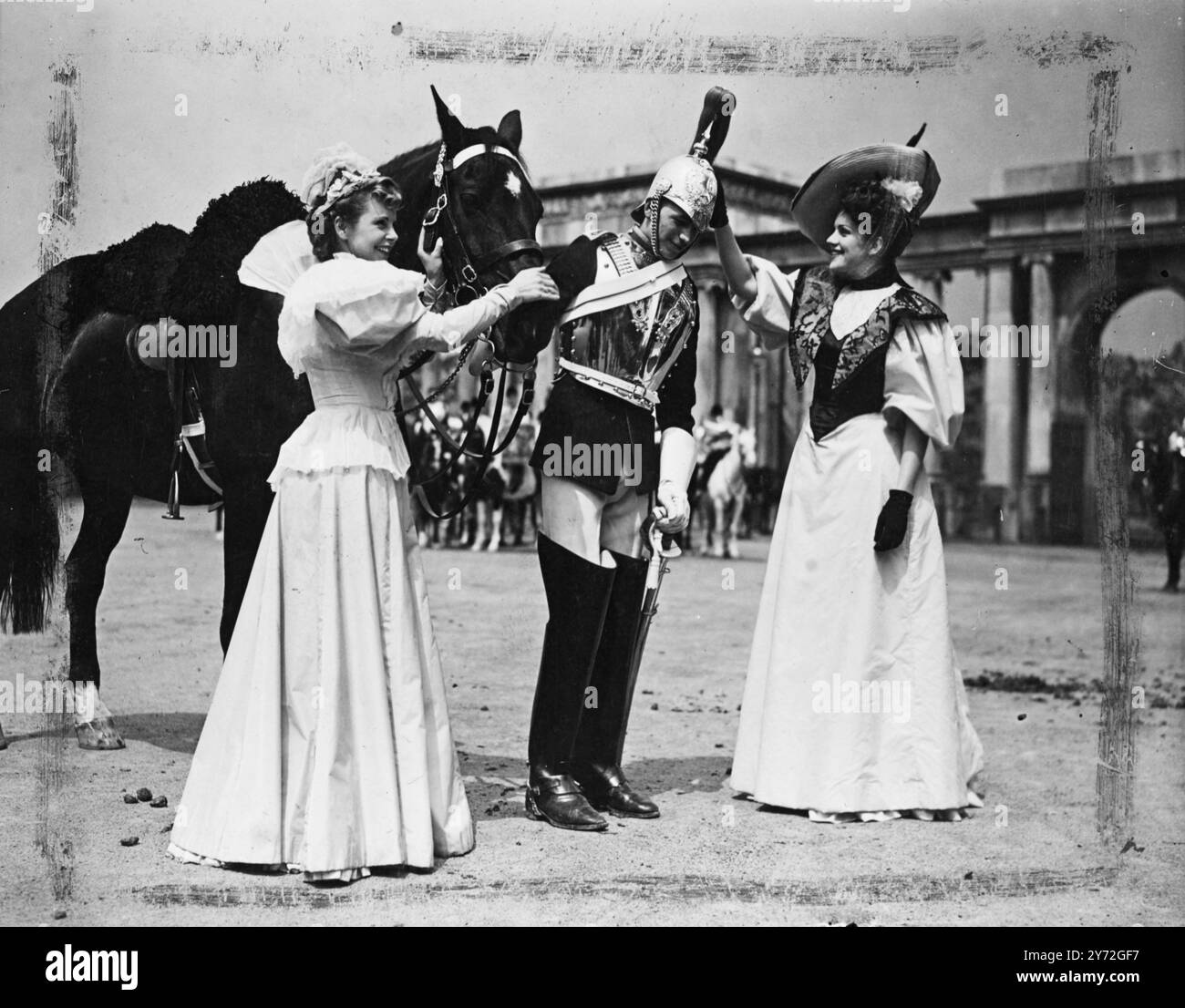 Un aperçu pittoresque de Londres au siècle dernier a été vu aux studios Shepperton aujourd'hui lorsqu'une troupe de Royal Horse Guards, en costume complet pour la première fois depuis la guerre, est apparue dans des scènes tournées pour les productions londoniennes de Sir Alexander Calder 'an Ideal Husband'. Sur une vaste scène construite pour ressembler au coin de Hyde Park de l'époque dans des détails authentiques, les gardes ont passé devant les acclamations des dames crinolinées marchant avec leurs escortes à chapeaux hauts et à blouis. l'image montre : affection divisée. Miss victorienne sur la gauche se lie d'amitié avec le cheval tandis que son compagnon préfère le gua Banque D'Images