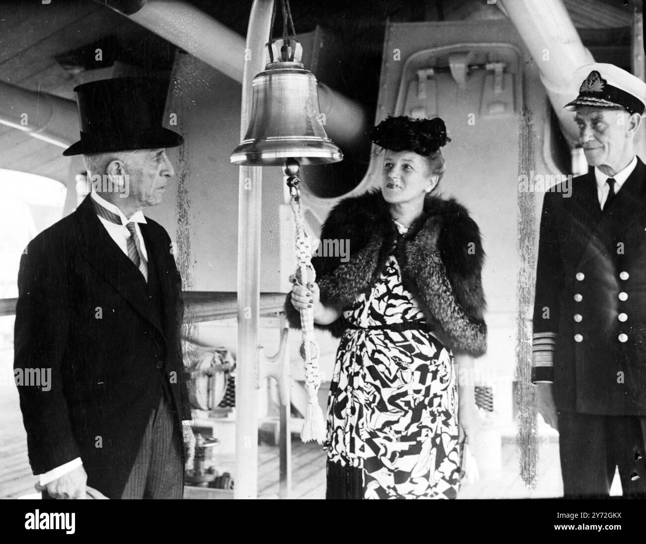 Une cloche de navire en argent et des bugles en argent étaient parmi les nombreux grands cadeaux d'argent qui ont été remis au HMS Bermuda, lors d'une cérémonie qui s'est tenue à Plymouth hier, mardi. Sir James Conyers, qui est président de la Chambre d'Assemblée des Bermudes, a fait voler ces jetons du peuple des Bermudes pour la cérémonie de présentation. Images : Lady Conyers sonne sept cloches sur la Silver Bell présentée hier sur le HMS Bermuda. 25 juin 1947 Banque D'Images