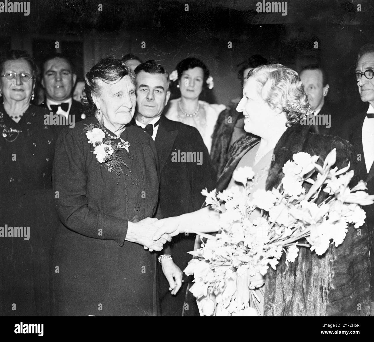 "Reine" du ballon, âgée de 90 ans. Mme Amy Lock, 90 ans, de Bristol, est la reine des showmen. Elle s'est rendue à Londres pour assister au Showmen's Guild Ball à Grosvenor House, Park Lane, ce soir (mardi), le premier rassemblement des membres de la Guilde depuis 1939. La Guilde prépare des plans pour relancer les carnavals et les foires britanniques. Images, Mme Lock étant accueillie par Mme H. P. Studt, épouse du président de la section londonienne de la Guilde des showmen à son arrivée à Grosvenor House ce soir (mardi). 29 janvier 1946 Banque D'Images