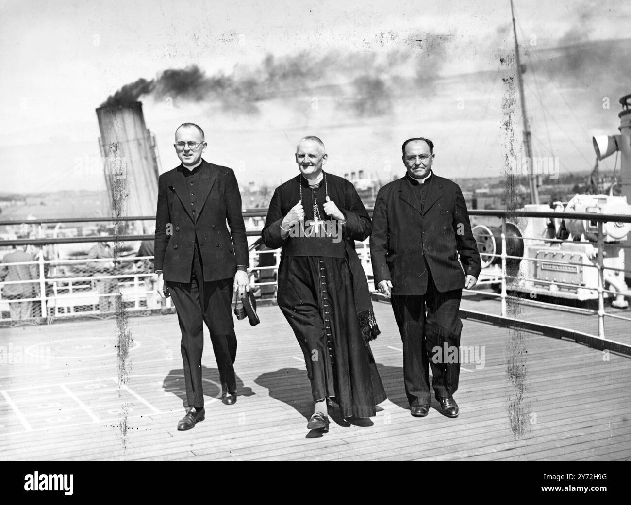 Son éminence, le cardinal Gerlier, archevêque de Lyon, était passager à bord du «Queen Elizabeth» quittant Southampton aujourd'hui. Le Cardinal est en route pour le Congrès de notre dame, qui se tiendra à Ottawa du 18 au 22 juin. Cardinaux et évêques dirigeront un rassemblement de milliers de prêtres catholiques du monde entier. Accompagnant son éminence dans son voyage à Ottawa, son secrétaire particulier, le chanoine Jean Maury, et Monseigneur Trocellier, O.M.I, Vicaire appostolique de MacKenzie, dans le Nord du Canada. 4 juin 1947 Banque D'Images