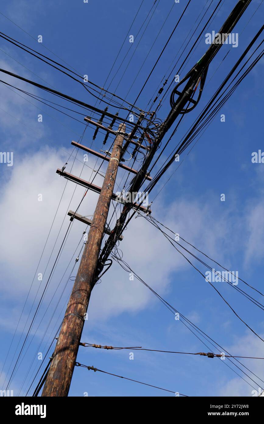 : Photos montrant des lignes électriques, des coins de rue et des voitures avec un ciel bleu clair et une infrastructure urbaine en arrière-plan. Banque D'Images