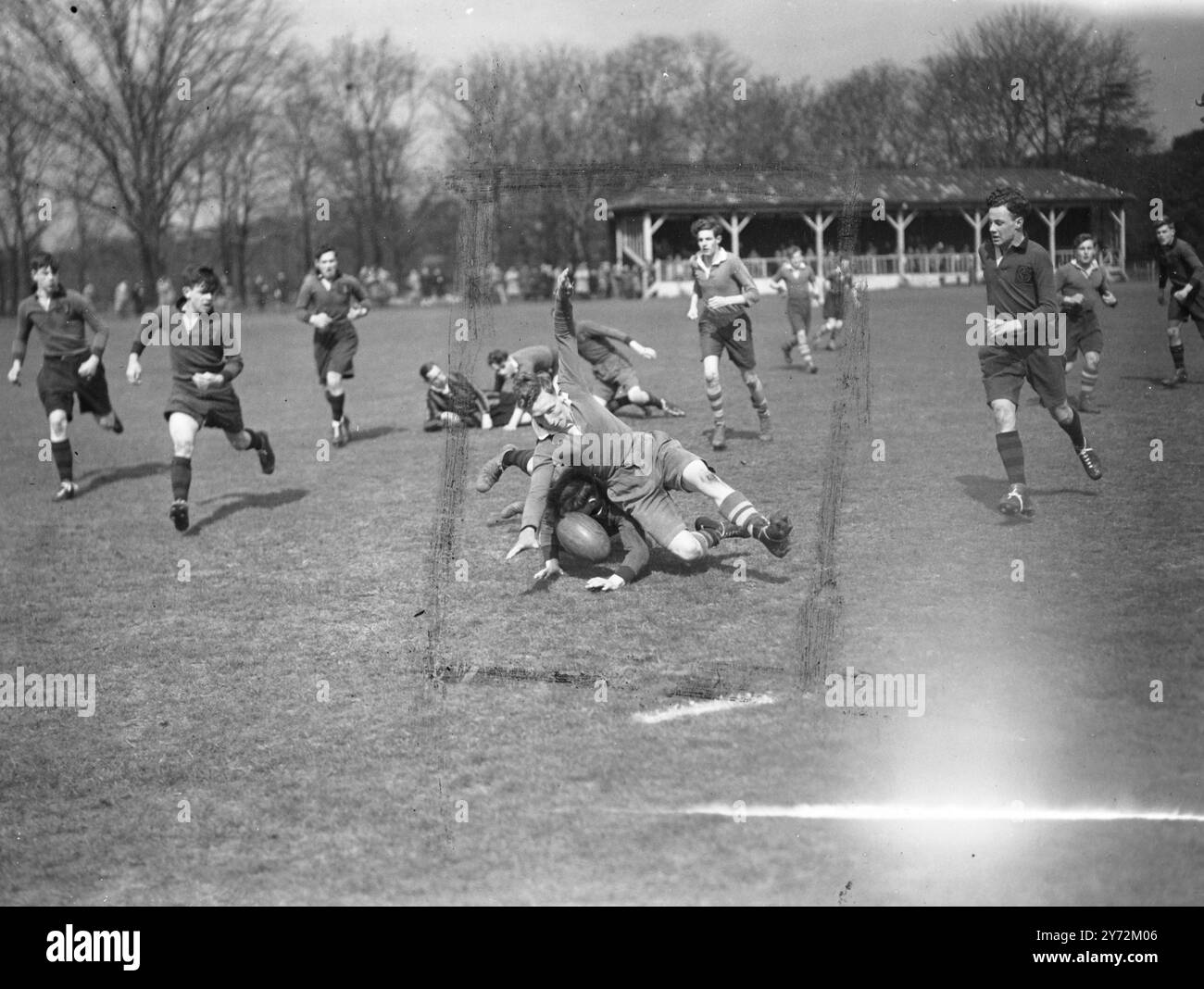 La compétition de rugby à sept de l'école publique a commencé ce matin au Rosslyn Park Ground dans Old Deer Park, Richmond. Image montre : un incident pendant le match dans le tour un de la compétition entre Cranbrook dans les écoles de Coleford, quand un joueur de Coleford étouffé par un défenseur de Cranbrook. 9 avril 1947 Banque D'Images