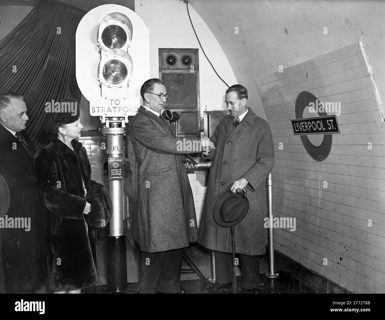 Le RT. Hon. A.J. Barnes, député, ministre des Transports, a déclaré ouverte la première section de l'extension est du Central London Railway de Liverpool Street à Stratford. Cette extension est la première liaison de l'un des projets les plus importants de Londres en matière de transport - en fin de compte, le service sera étendu à Loughton, Essex, Newbury Park et Ongar. Des tunnels pour l'extension, d'une longueur totale de 8 1/4 miles, ont été construits avant la guerre, et pendant les hostilités, utilisés comme abris. La photo montre : la clé d'or que le ministre des Transports (à droite) a utilisée pour ouvrir le système de signalisation pour inaugurer un nouveau E. Banque D'Images