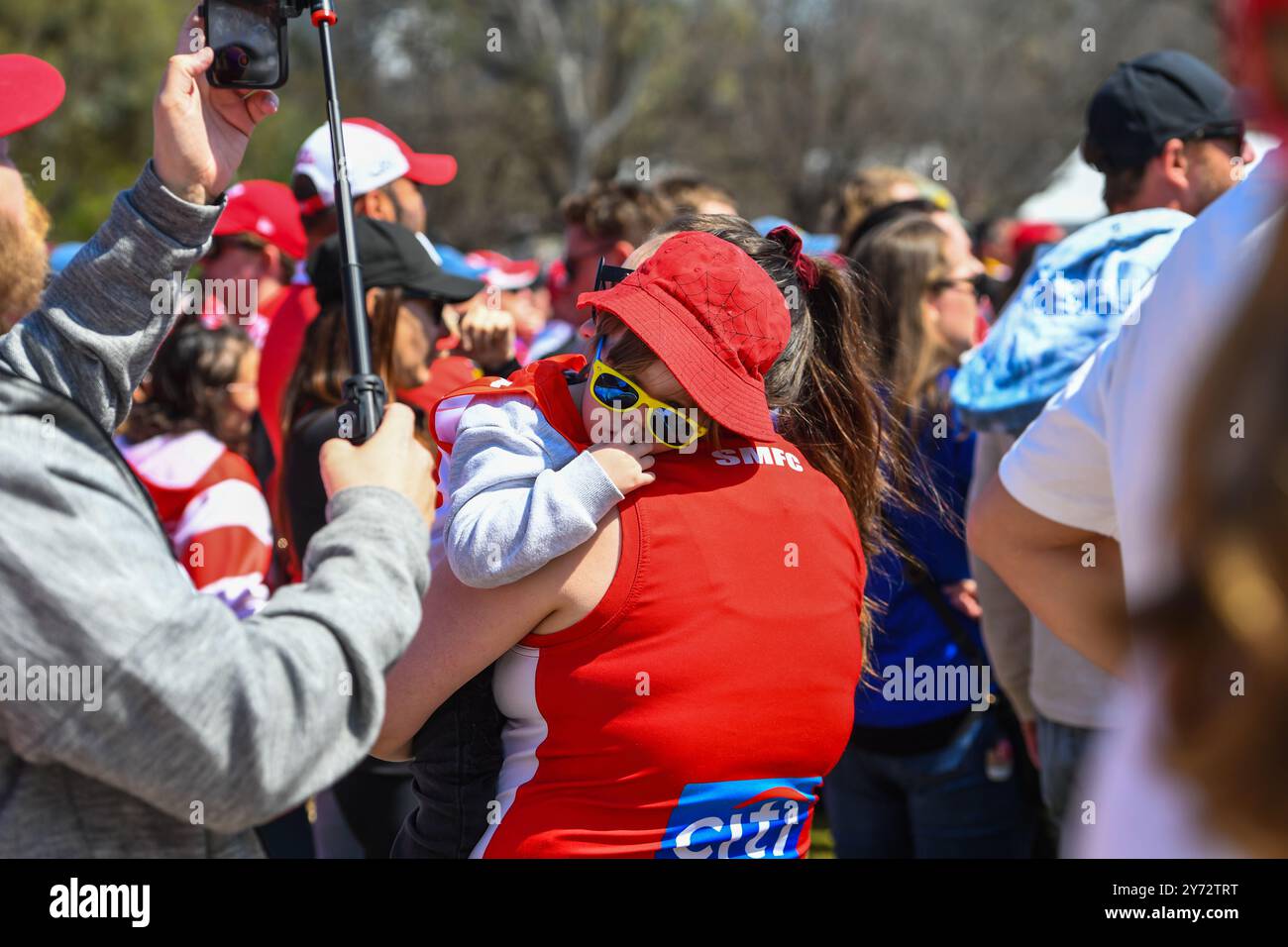 Melbourne, Australie. 27 septembre 2024. La jeune supporter des cygnes de Sydney est vue se reposer sur l'épaule de sa mère au Footy Festival avant le match de la Grande finale de l'AFL. Le défilé de la Grande finale de l'Australian Football League et le Footy Festival prennent le relais à Yarra Park devant le Melbourne Cricket Ground Stadium avant l'AFL ? Grande finale. L'événement propose des divertissements pour tous les âges, notamment des apparitions de joueurs, des cadeaux, une zone de jeu AFL, de la musique et certains des meilleurs food trucks et bars de Melbourne. (Photo de Alexander Bogatyrev/SOPA images/SIPA USA) crédit : SIPA USA/Alamy Live News Banque D'Images