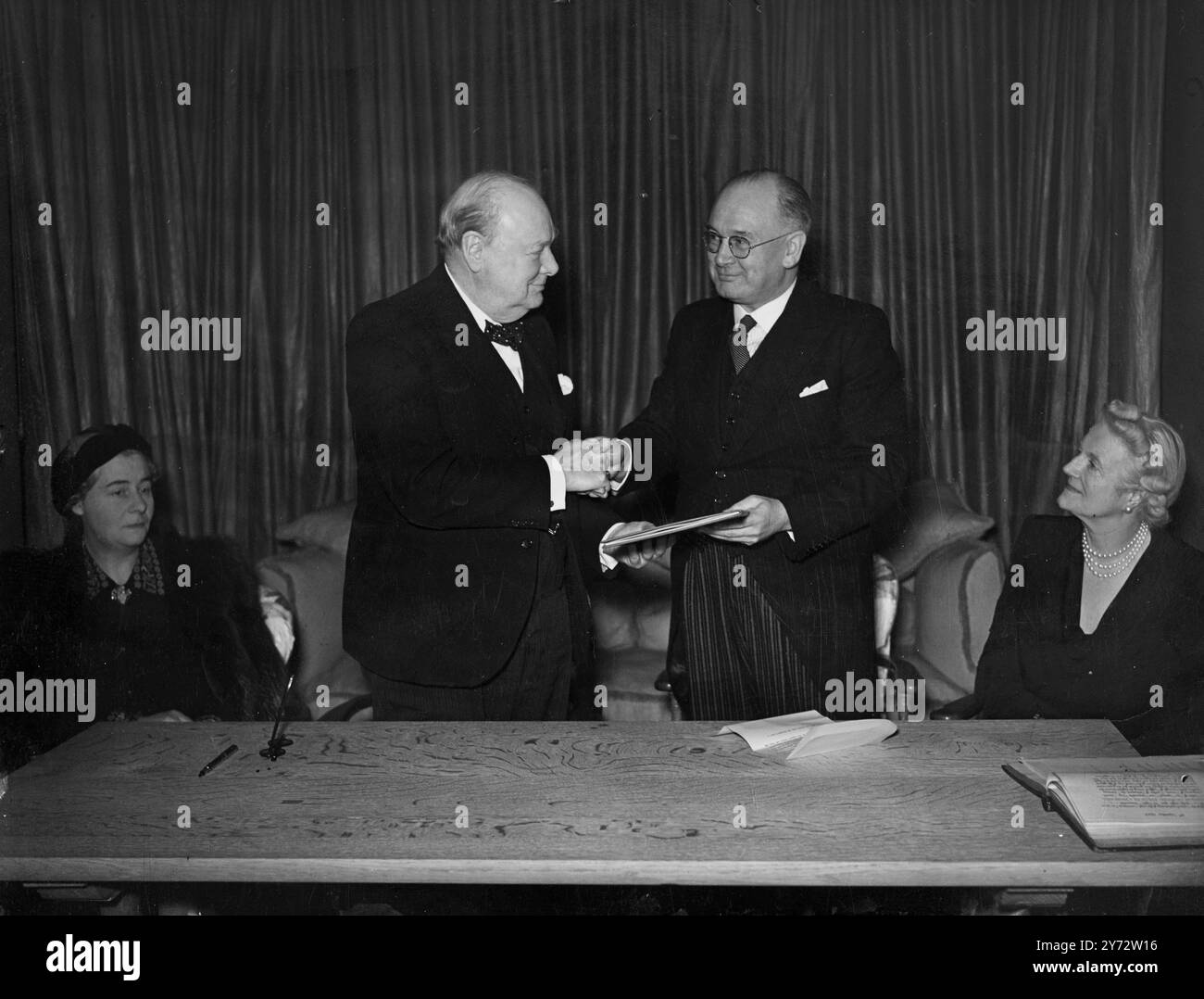La liberté de l'arrondissement de Stafford a été conférée à la RT. Hon. Winston Churchill (debout à gauche) à sa résidence londonienne par le maire de Stafford, H. Wallace-Copland (debout à droite) et le greffier de la ville - M. T. Broughton Newell était présent. 7 novembre 1946 Banque D'Images