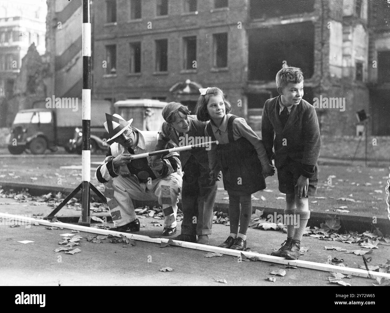 Une campagne intensive pour sensibiliser les enfants londoniens aux dangers de la route et leur apprendre à les éviter, qui se déroule maintenant sous la direction de la police métropolitaine. Les cours sur la sécurité routière sont d'abord donnés dans les salles de classe et les enfants sont emmenés dans la rue avec des enseignants policiers pour mettre la leçon en pratique. L'image montre: "Safety Sam" dit aux enfants qu'ils doivent s'arrêter, regarder et écouter avant de traverser la route - un incident dans la leçon de sécurité routière tenue à South Square. 4 novembre 1946 Banque D'Images