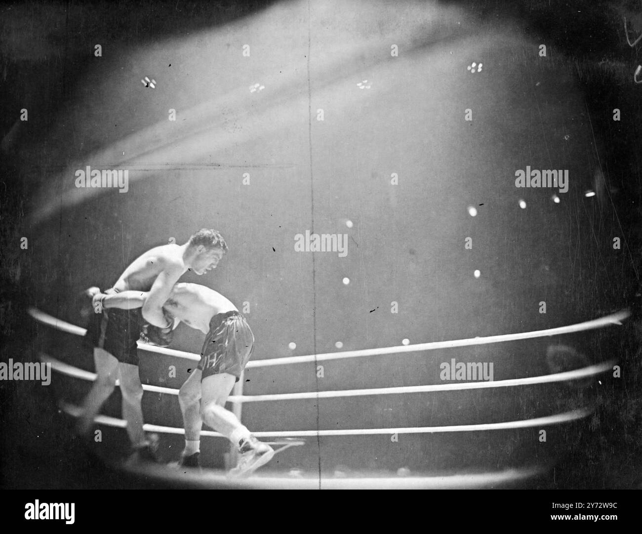 Dans un combat qui a duré les 15 rounds complets, Vince Hawkins d'Eastleigh, a battu Ernie Roderick, de Liverpool, aux points au Royal Albert Hall. Roderick défendait son titre de champion britannique des poids moyens. Picture Shows : une scène au cours du 12e round du combat dans laquelle Roderick (portant un short rayé) montre une expression de douleur alors que Hawkins entre dans sa garde à l'Albert Hall. 28 octobre 1946 Banque D'Images