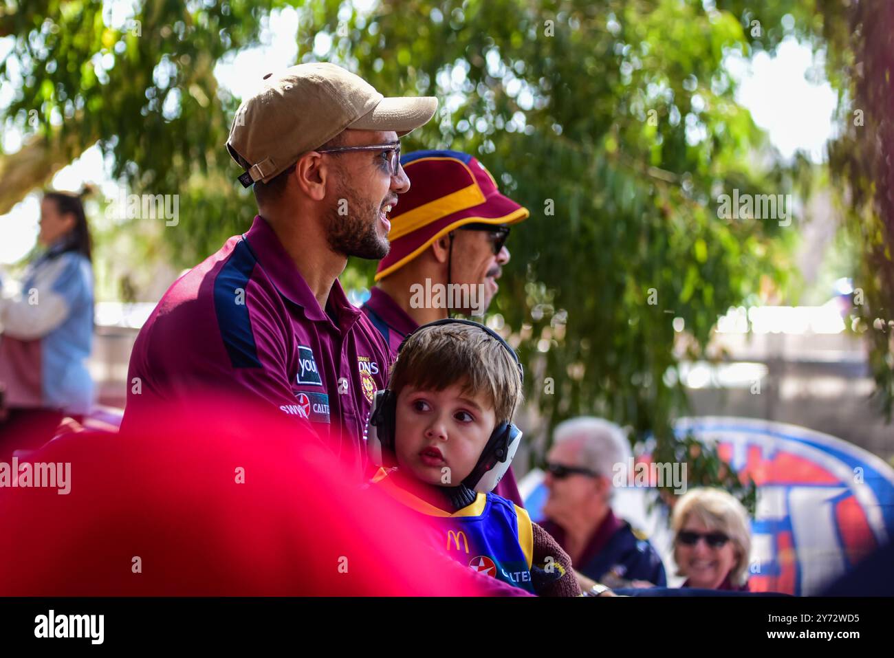 Melbourne, Australie. 27 septembre 2024. CAL Ah Chee (F) avec son fils et Charlie Cameron (B) de Brisbane Lions sont vus pendant l'événement. Le défilé de la Grande finale de l'Australian Football League et le Footy Festival prennent le relais à Yarra Park devant le Melbourne Cricket Ground Stadium avant l'AFL ? Grande finale. L'événement propose des divertissements pour tous les âges, notamment des apparitions de joueurs, des cadeaux, une zone de jeu AFL, de la musique et certains des meilleurs food trucks et bars de Melbourne. (Photo de Alexander Bogatyrev/SOPA images/SIPA USA) crédit : SIPA USA/Alamy Live News Banque D'Images