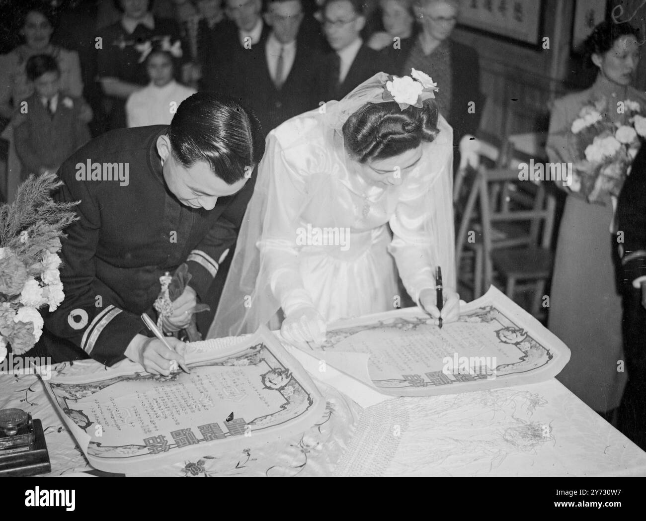 Soho mais pas Cathay. En Chine, un festin de mariage peut consister en des centaines de cours et durer trois jours, mais quand Mlle Frances Chang a épousé Lieut Yu Chang Chu, de la marine chinoise, dans le restaurant Soho (Londres), dont elle est directrice générale aujourd'hui (dimanche) . Toutes les célébrations étaient limitées par des conditions. La cérémonie a été effectuée par le consul chinois à Londres, M. Tan, qui se tenait devant deux portraits du Dr Sun Yat Sen, fondateur de la Chine moderne, selon la coutume chinoise, mariés et mariés se sont rencontrés en dehors du lieu du mariage et se sont engagés ensemble. Une introduction formelle a suivi bef Banque D'Images