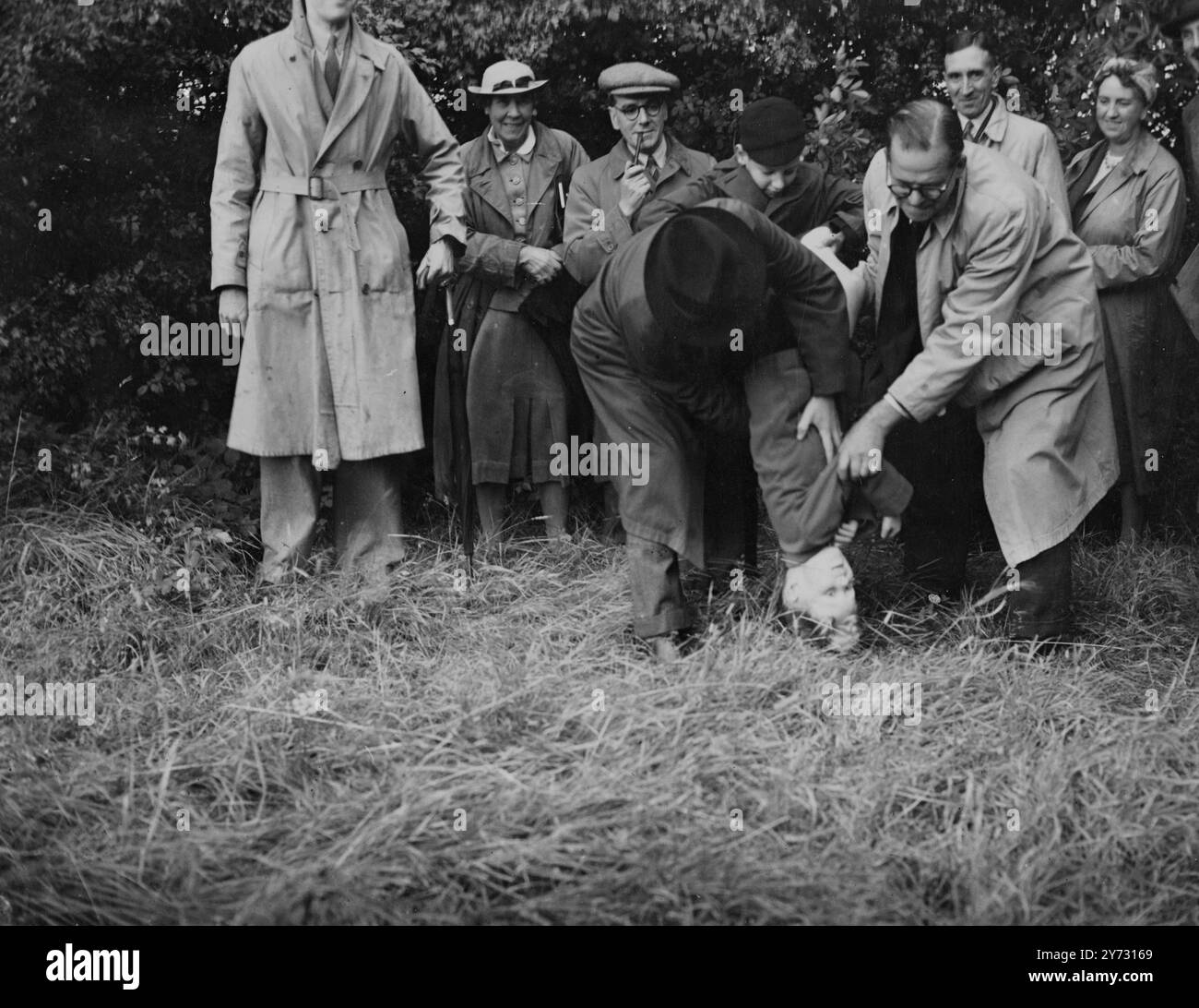 Il le fait sur sa tête. Adrian Reid, 7 ans, de Mill Hill, Londres, a battu les limites de la paroisse de Hendon lorsque la cérémonie antique a eu lieu pour la première fois ce siècle, aujourd'hui (samedi). Selon la tradition, lorsque les vieilles pierres de limite sont trouvées, le plus jeune membre du parti est normalement «battu» en ayant sa tête collée sur le sol, canard dans un étang ou roulé dans la boue, mais la mère d'Adrian a interdit aux batteurs de salir les vêtements de son fils, en raison de la pénurie de savon et de coupons, donc Adrian a été «heurté» quelques fois de plus à la place de buter et rouler dans la boue. Les photos montrent, yo Banque D'Images