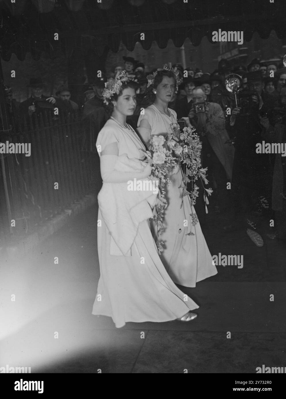 La princesse Elizabeth dans la longue robe à jupe de crème, avec une courte cape de fourrure blanche, était l'une des demoiselles d'honneur à St Margaret's Westminster, cet après-midi, lorsque sa dame d'attente, l'honorable Mme Vickery Gibbs, était mariée au capitaine l'honorable Andrew Elphinstone, un neveu de la reine. Leurs majestés le Roi et la Reine, sa Majesté la Reine Mary et la Princesse Margaret ont assisté au mariage. 29 mai 1946 Banque D'Images