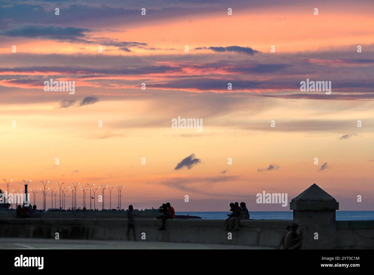 749 ciels brûlants au coucher du soleil illuminent le crépuscule sur le parapet de la digue du parc Parque Maceo de l'esplanade Malecon. La Havane-Cuba. Banque D'Images
