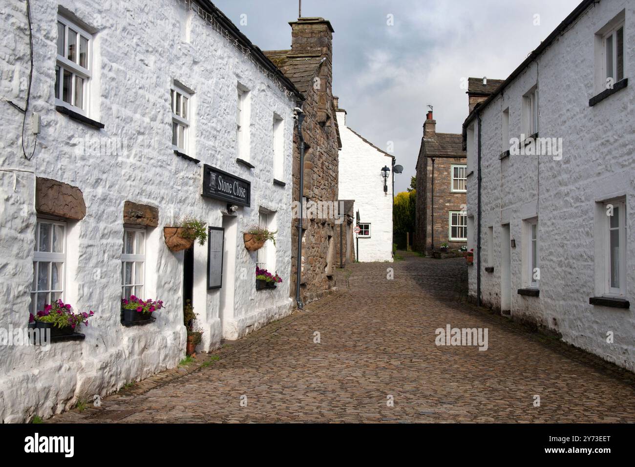 Chalets blanchis à la chaux dans les rues pavées étroites du village dent célèbre pour ses 'dent Knitters', Dentdale, Yorks Dales National Park, Cumbria, Angleterre Banque D'Images