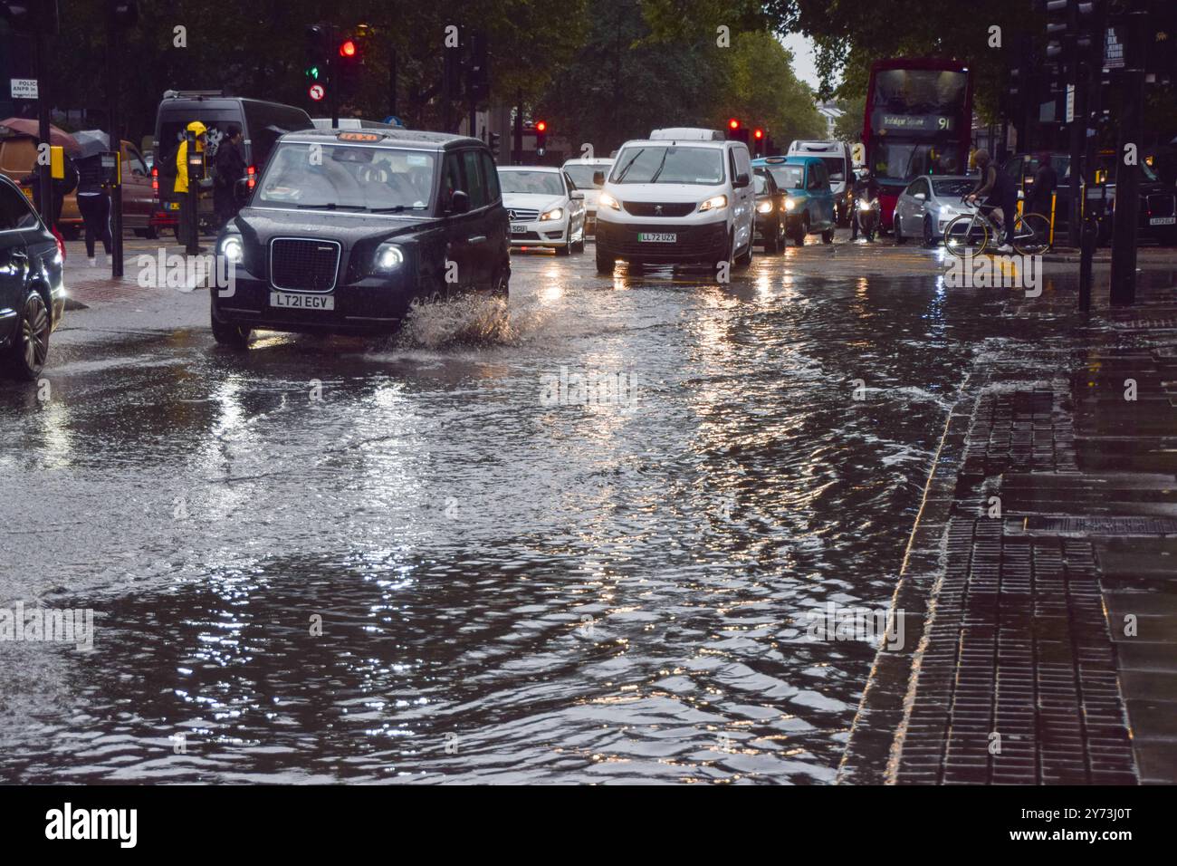 Londres, Royaume-Uni. 27 septembre 2024. Les voitures traversent une Euston Road obstruée par l'eau alors que des avertissements d'inondation sont émis en Angleterre sous de fortes pluies. (Photo de Vuk Valcic/SOPA images/SIPA USA) crédit : SIPA USA/Alamy Live News Banque D'Images