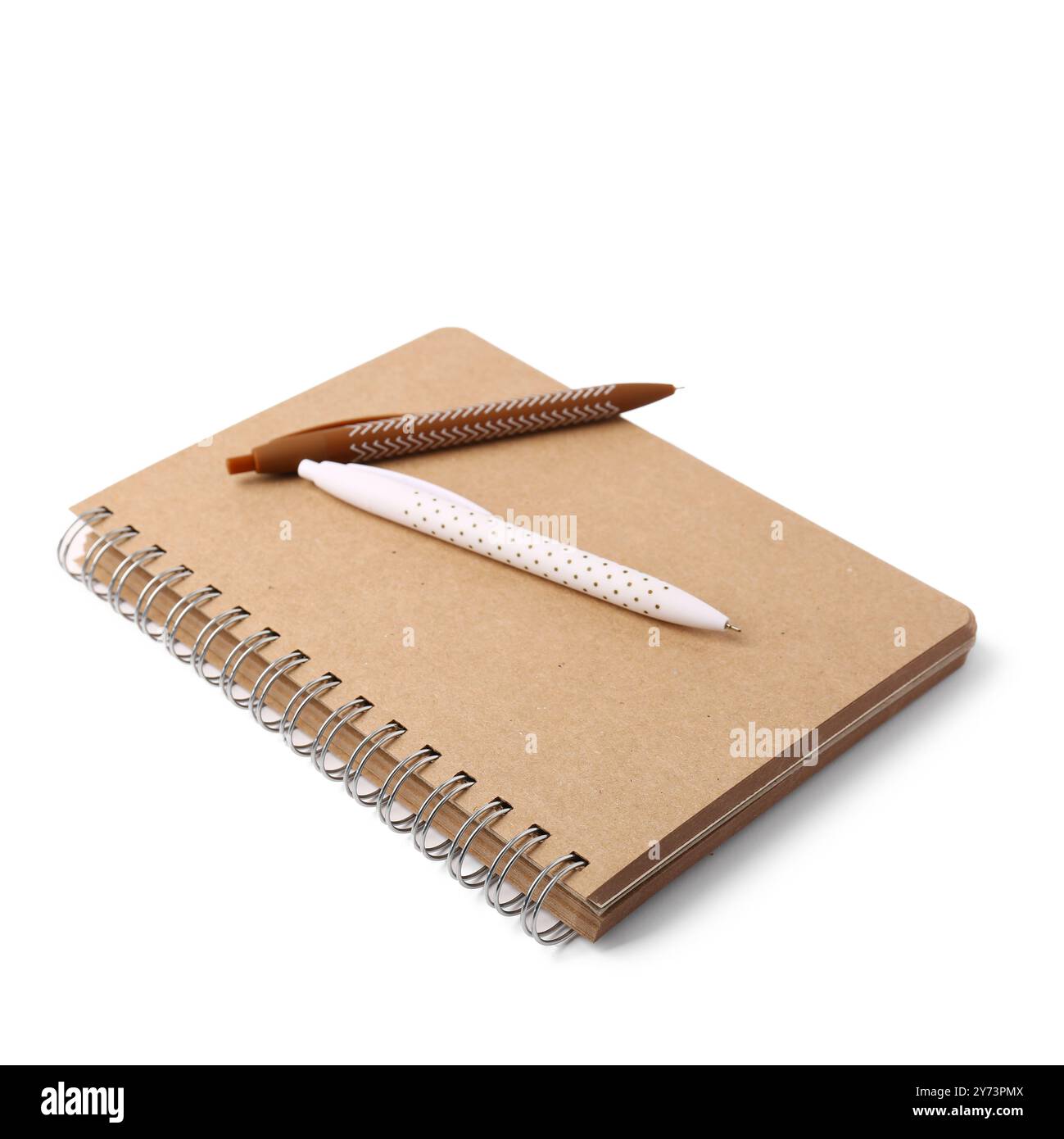 Cahier beige et stylos sur fond blanc Banque D'Images