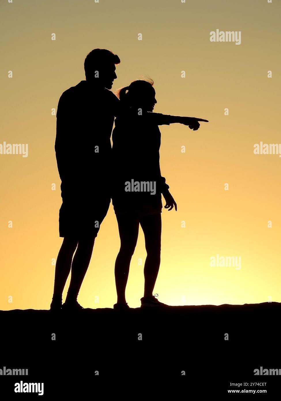 Une série de silhouettes captivantes représentant un couple partageant de tendres moments au coucher du soleil, créant une atmosphère sereine et romantique. Banque D'Images