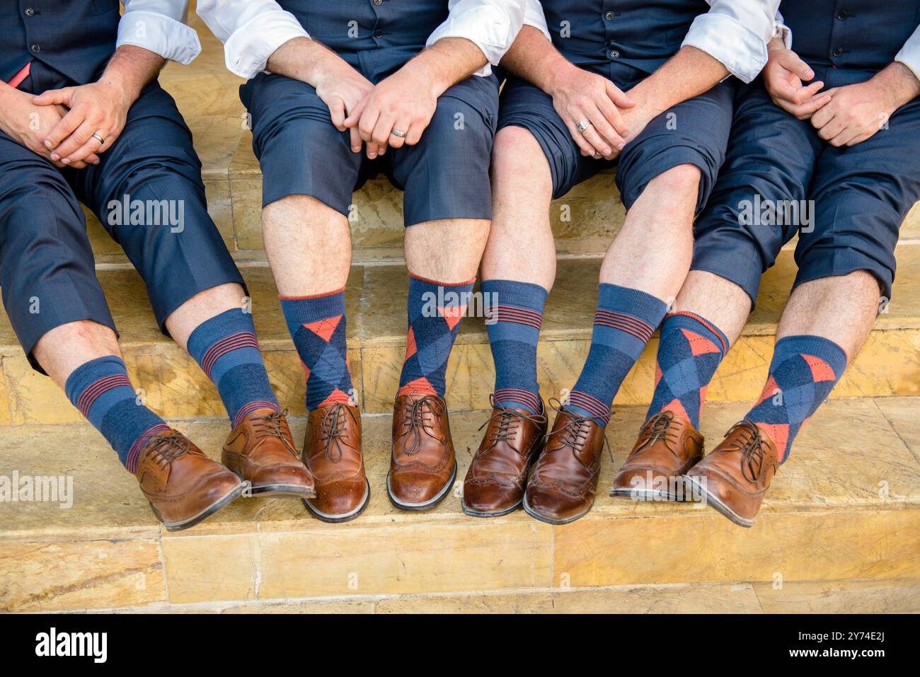 Photographie des mains, des jambes et des pieds de quatre hommes d'honneur bien habillés Banque D'Images