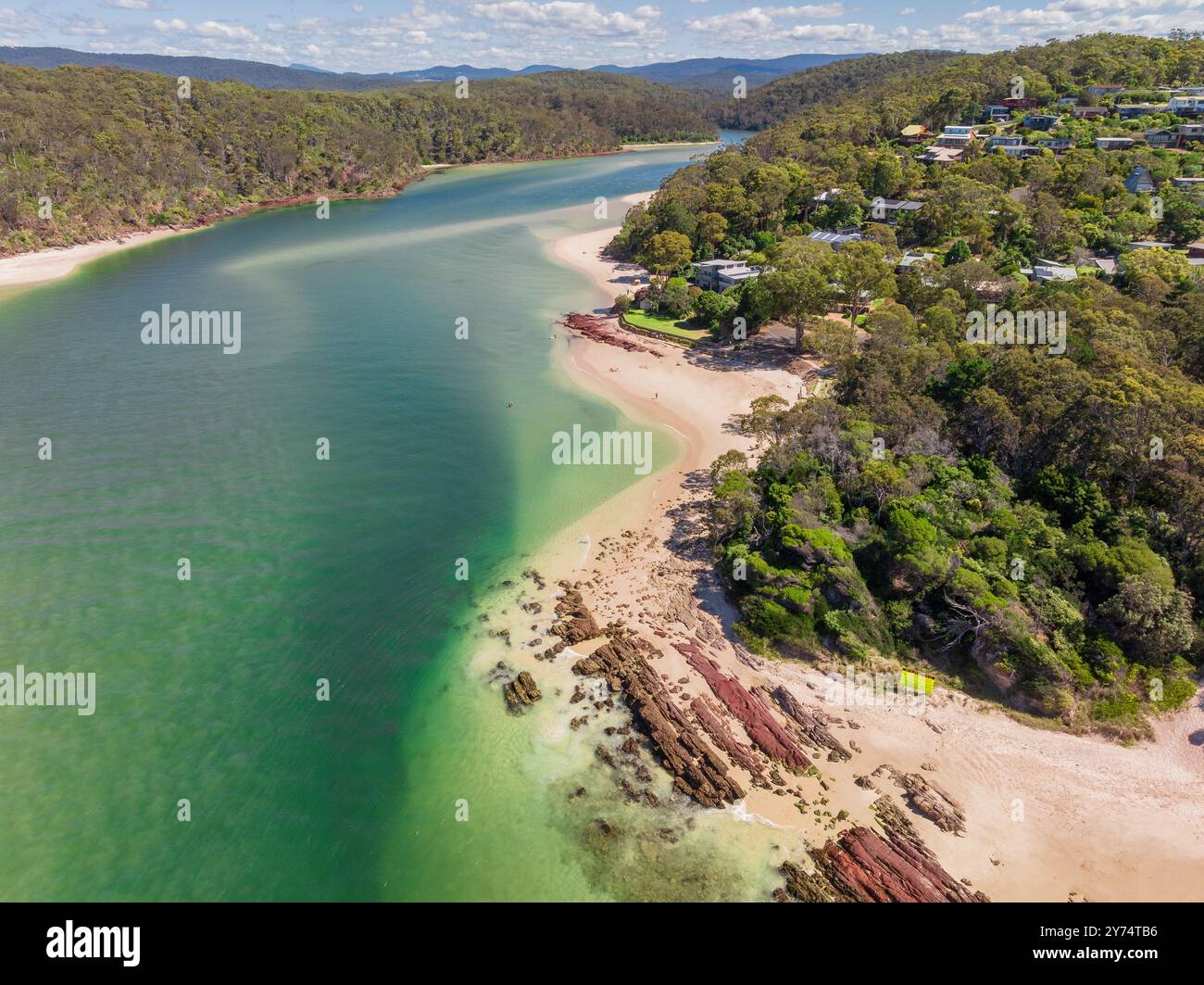 Vue aérienne de l'océan turquoise autour d'une rivière qui coule le long des plages de sable de Pambula Beach dans le sud de la Nouvelle-Galles du Sud, Australie. Banque D'Images
