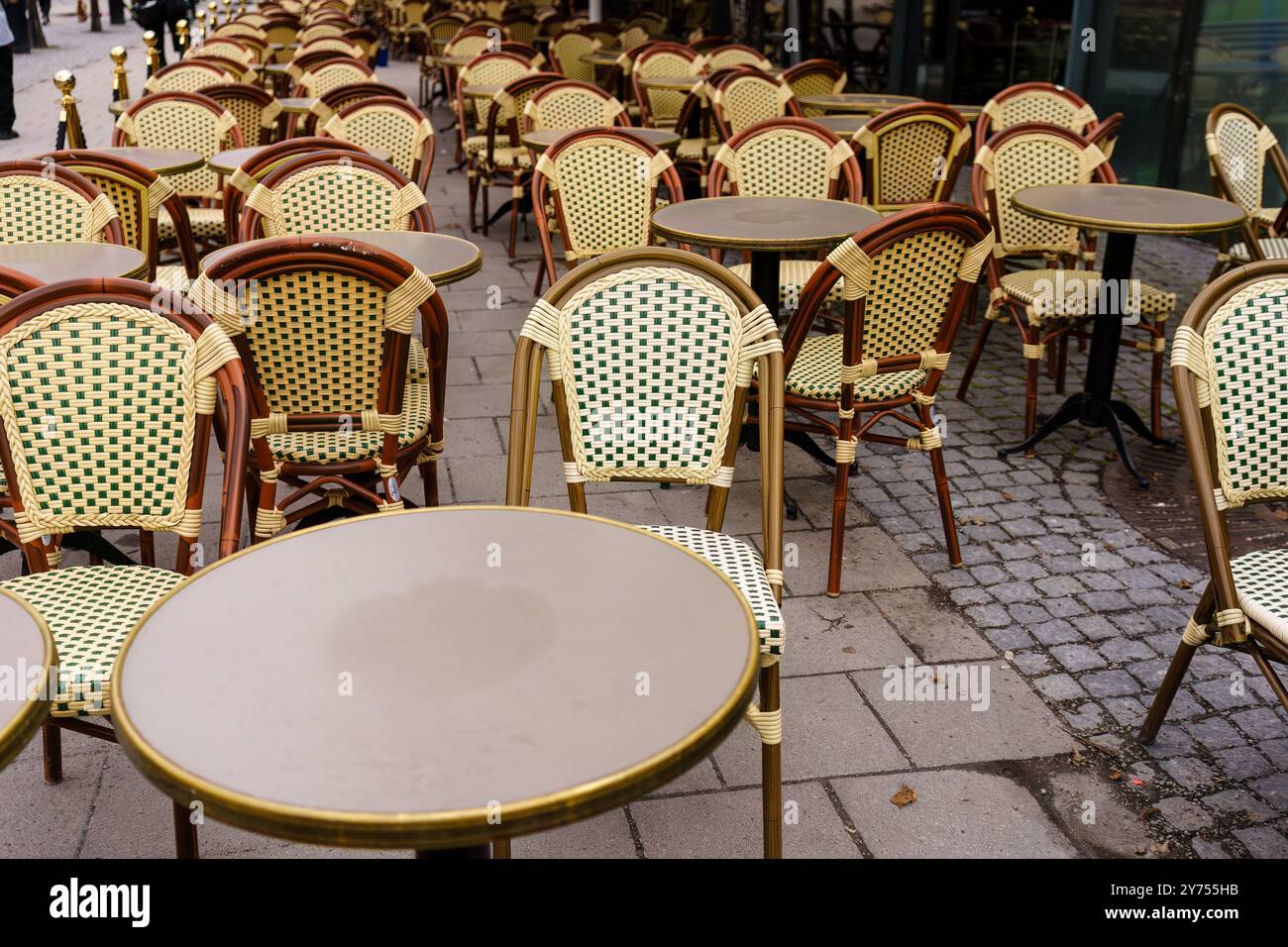 Des chaises et des tables en osier vides au café européen en plein air par une journée nuageuse Banque D'Images