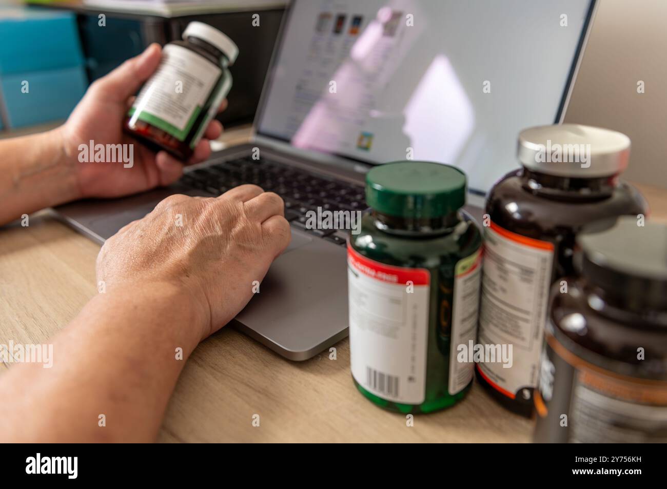 Un concept d'utilisation de la technologie avec une personne utilisant un ordinateur portable pour rechercher en ligne des informations et apprendre sur les suppléments de santé. Banque D'Images