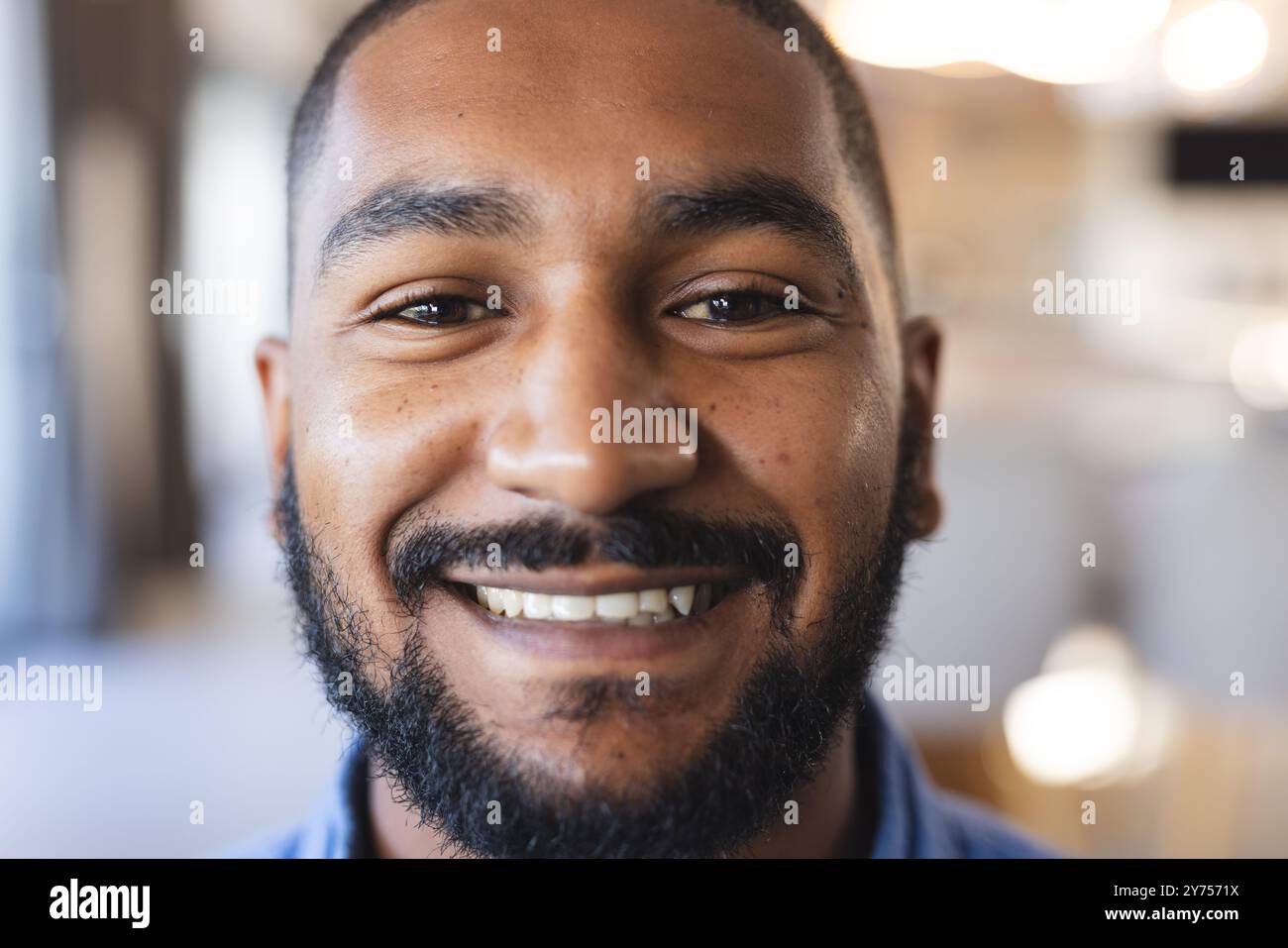 Homme souriant profitant du temps avec divers amis pendant le repaire décontracté à l'intérieur, à la maison Banque D'Images