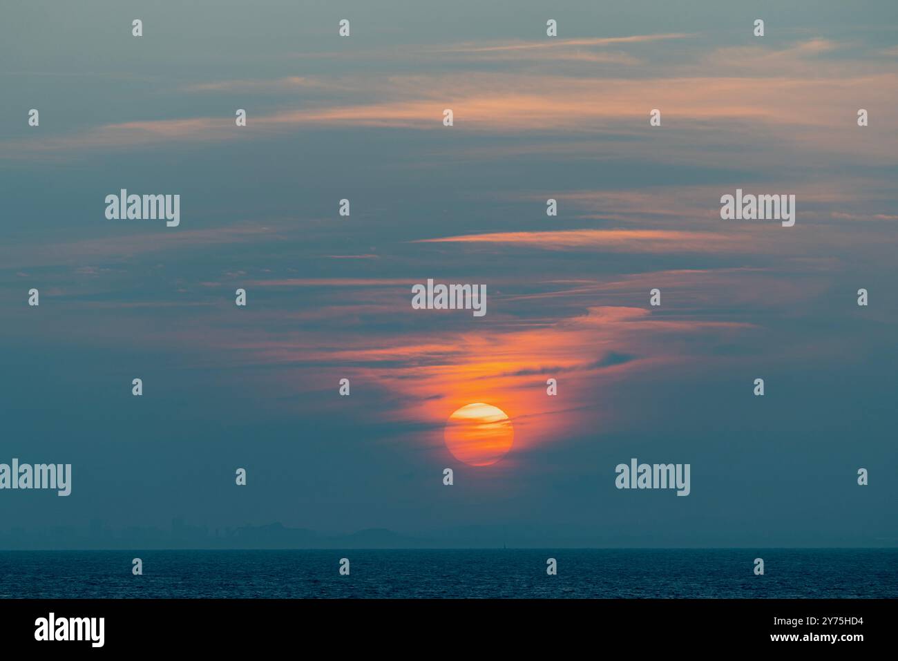 La disparition lente dans les nuages au-dessus de la côte galloise au coucher du soleil Banque D'Images