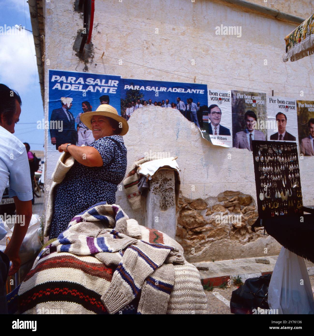 Eine Frau verkauf t Wollpullover an ihrem Markstand beim Straßenmarkt in San Francesc auf Formentera, Spanien um 1982. Banque D'Images