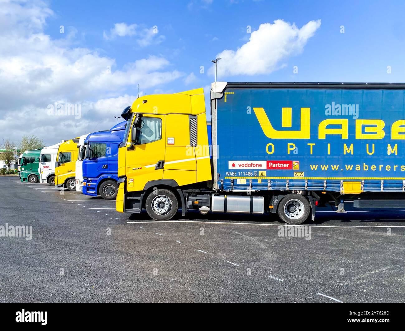 Camions garés dans un parc de camions à une station-service d'autoroute. - Image de stock capturée avec un smartphone