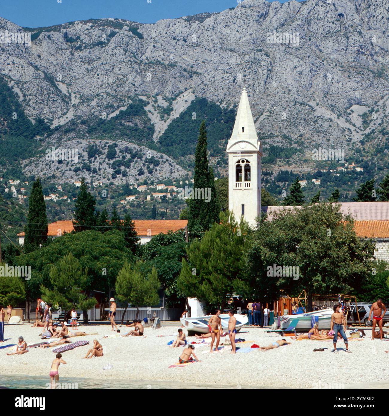 Hinter dem Strand von Makarska steht die : Philipp Neri Kirche, hinter der Stadt erhebt sich das Biokovo Bergmassiv in der Region Kroatien, Jugoslawien um 1981. Banque D'Images