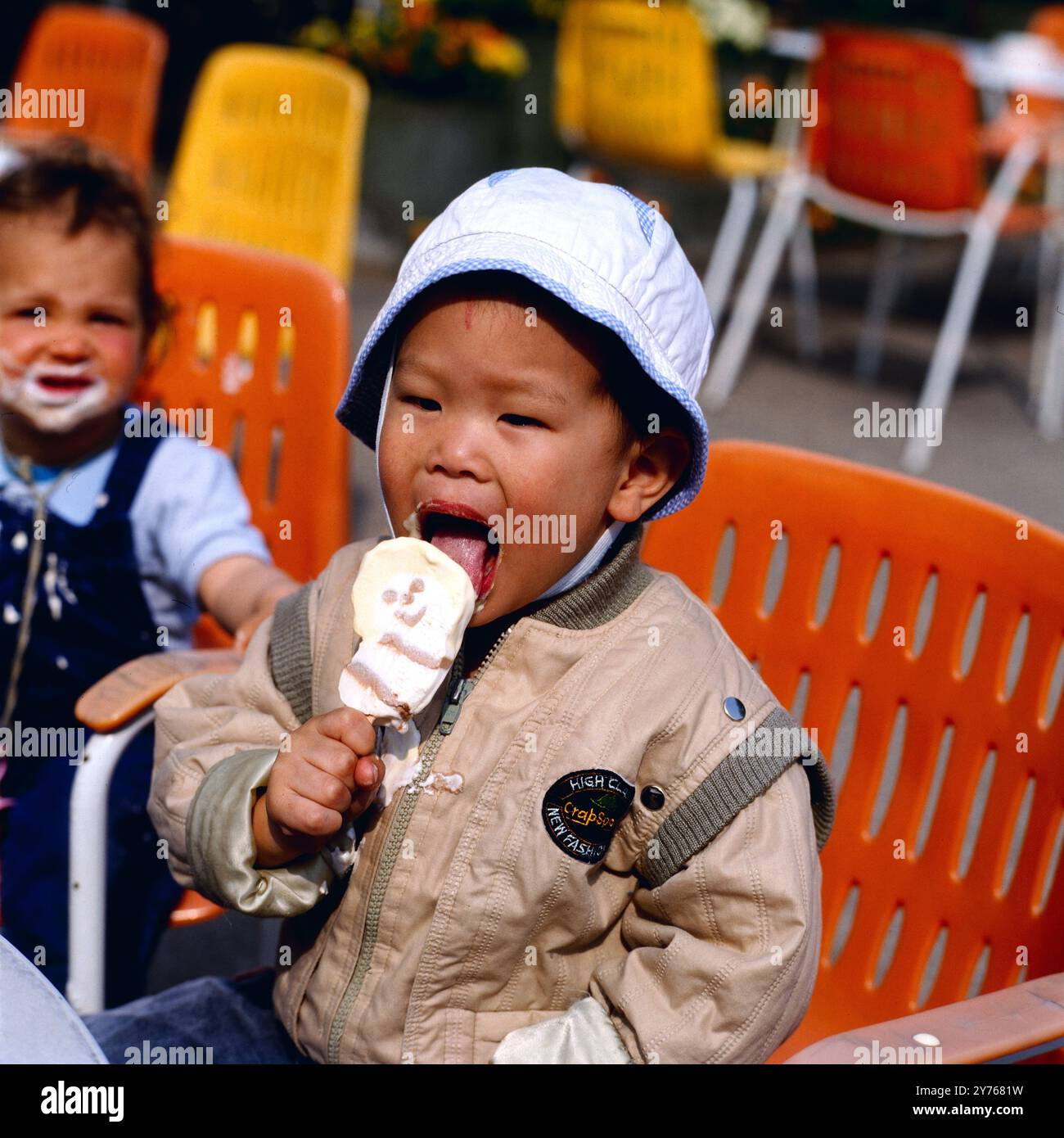 Kleiner asiatischer Junge beim Eisessen, Hamburg um 1986. Banque D'Images