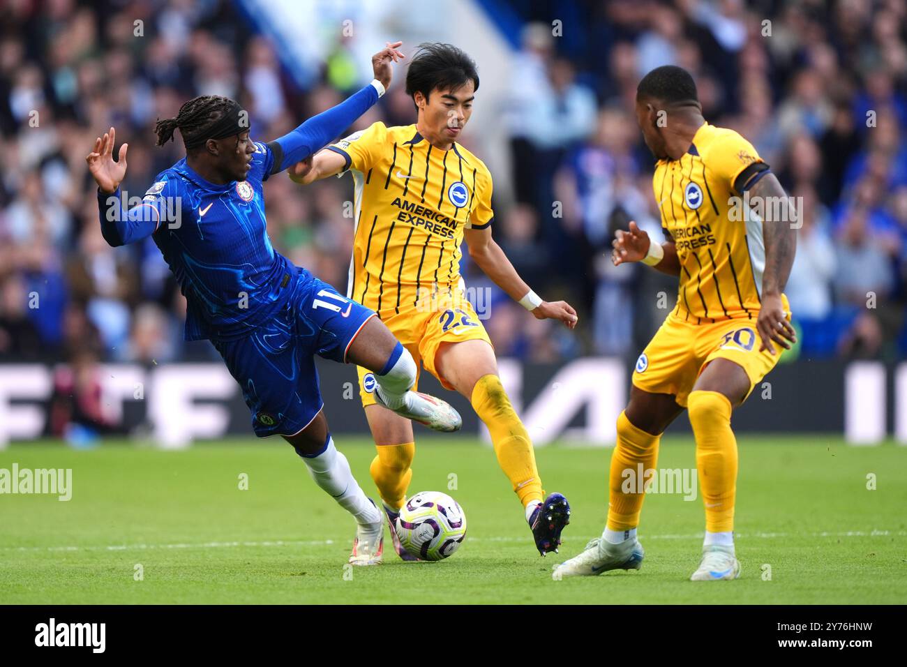 Noni Madueke de Chelsea (à gauche) se bat pour le ballon contre Kaoru Mitoma de Brighton et Hove Albion et Pervis Estupinan (à droite) lors du match de premier League à Stamford Bridge, Londres. Date de la photo : samedi 28 septembre 2024. Banque D'Images