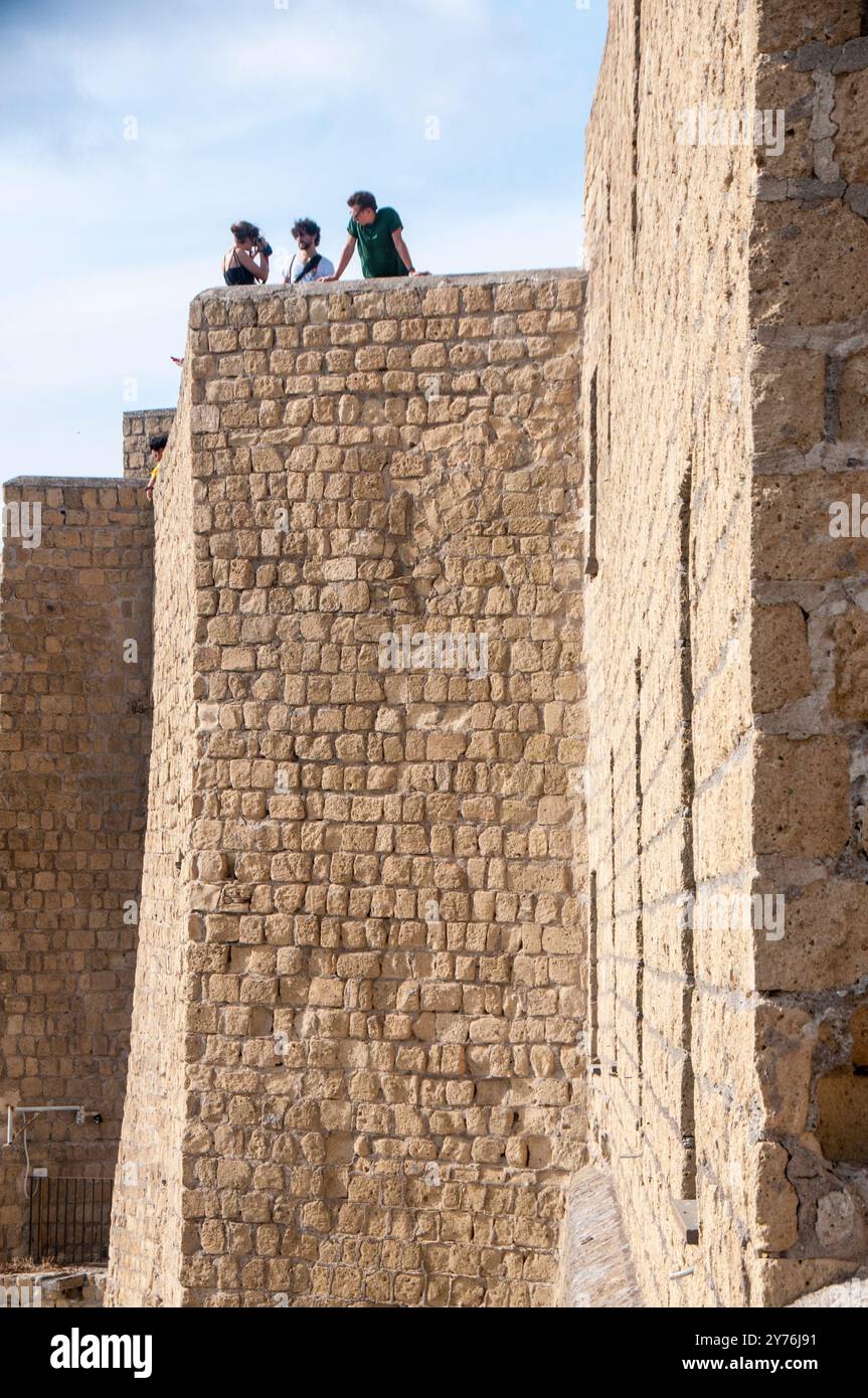 Du haut de la façade en tuf du Castel dell'Ovo, les touristes observent le panorama. Naples Banque D'Images